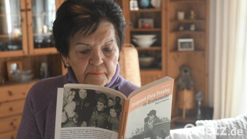 Dagmar Kiermeier blättert in dem Buch &quot;Sergeant Elvis Presley in Grafenwöhr&quot;. Das Foto auf der Buchrückseite dokumentiert ihre Begegnung mit dem Weltstar als Zwölfjährige in Hirschau. Bild: Gabi Schönberger