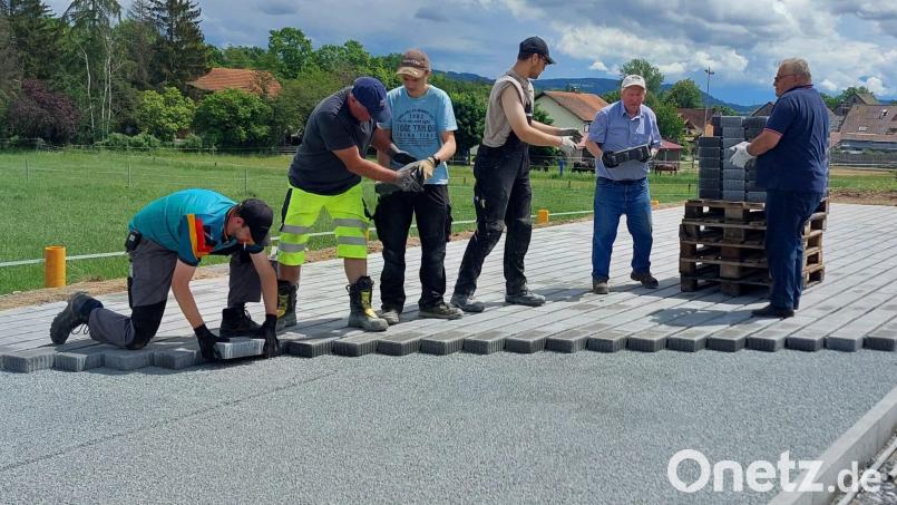 Bei der Befestigung des Parkplatzes scheuten Christof Engelbrecht (von rechts) und Konrad Merkl keine Mühe, neun Kilo schwere Steine abzuladen und weiterzureichen. Bild: Feuerwehr Immenreuth/exb