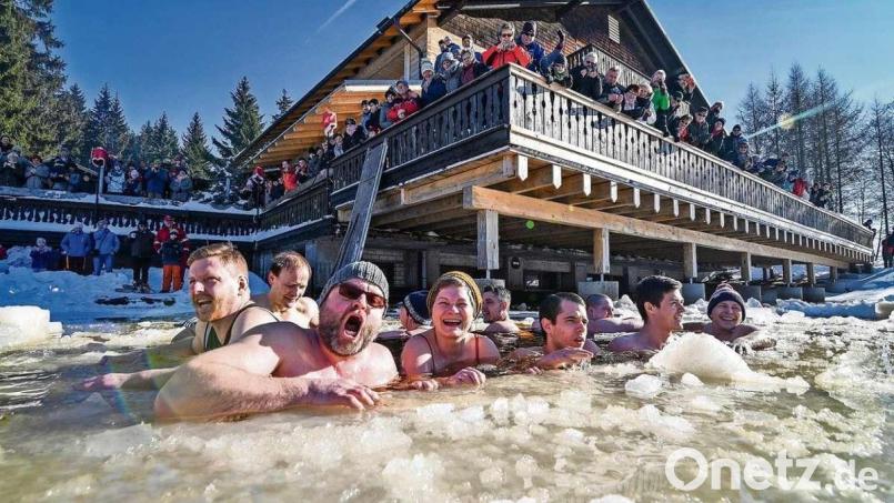 Eine Gruppe Hobby-Eisbader wagt beim Eisbade-Event am Fichtelsee den Gang ins kalte Wasser, angefeuert und fotografiert von zahlreichen Zuschauern auf der Terrasse des Waldhotels Fichtelsee. Archivbild: Florian Miedl/fph