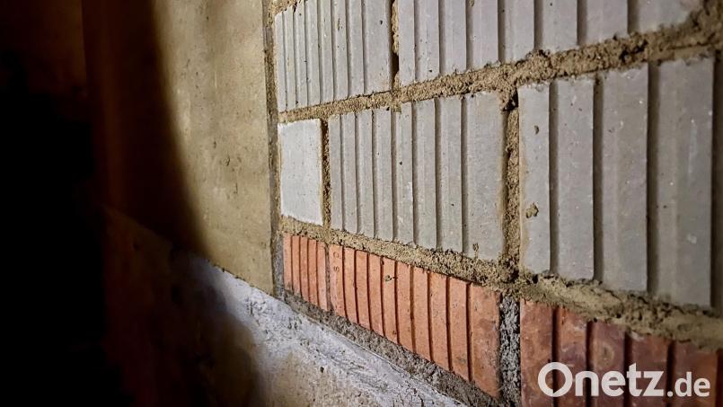 Eine Reihe gebrannter Ziegelsteine (rot) soll den Bau künftig vor Nässe von unten schützen. Bild: Gabi Schönberger