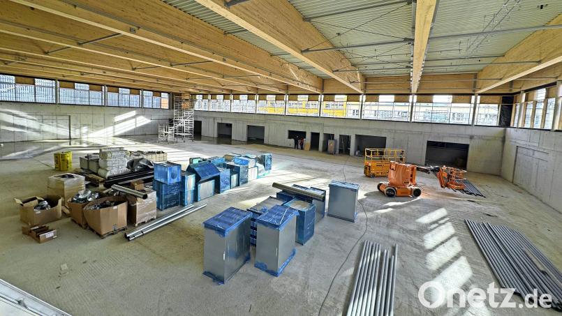 Noch ist die Dreifachturnhalle im Rohbauzustand. Die derzeit zu sehenden riesigen Holzbinder werden unter einer eingezogenen Decke verschwinden. Bild: Matthias Bäumler/fph