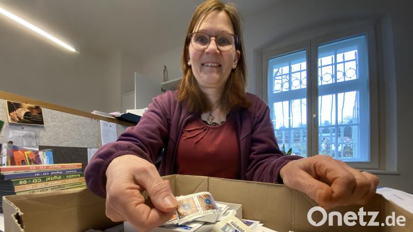 Pfarrsekretärin Martina Dotzler mit der Schachtel voller Briefmarken, die demnächst abgeschickt wird. Bild: gri