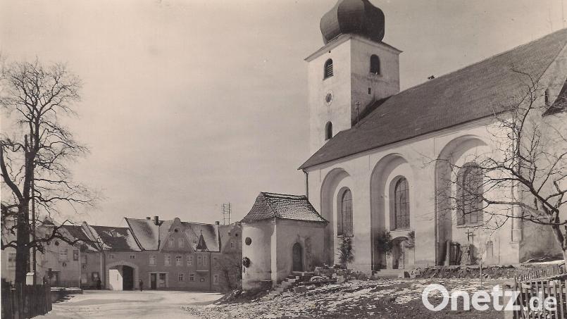 Das ehemalige Beinhaus (Bildmitte) stand einmal am heutigen Kirchplatz in Wiesau. Das Foto wurde vor 90 Jahren aufgenommen, als der alte Friedhof aufgelassen wurde und die Kirche noch kürzer war. Bild: Archiv Werner Robl