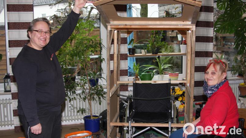 Das Frontfenster am nachgebildeten Traktor ist aufklappar. Im Inneren befindet sich ein Rollstuhl, wie Stephanie Mühlbauer und Martina Sötje (von links) demonstrieren. Bild: wro