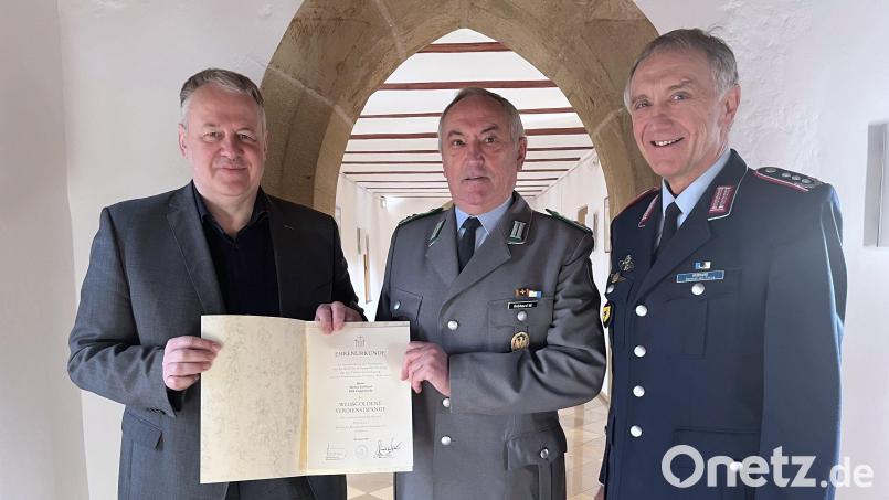 Landrat Richard Reisinger (links) händigt Werner Gebhard (Mitte) die weißgoldene Verdienstspange des Landesverbands Bayern im Volksbund Deutsche Kriegsgräberfürsorge aus. Begleitet wird der Geehrte von seinem Bruder Bertram Gebhard (rechts). Bild: Christine Hollederer