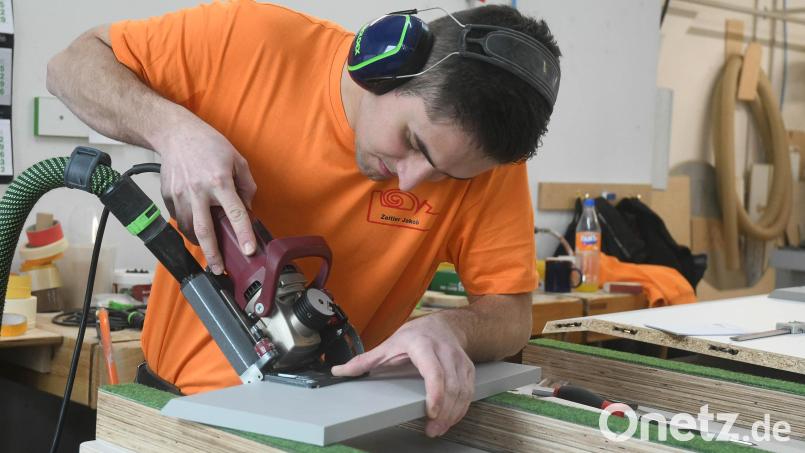 An einem Musterstück testet Jakob Zeitler, wie die Kante gefräst werden muss, damit ein Schrank unter eine Dachschräge und eine Treppe passt. Bild: Gabi Schönberger