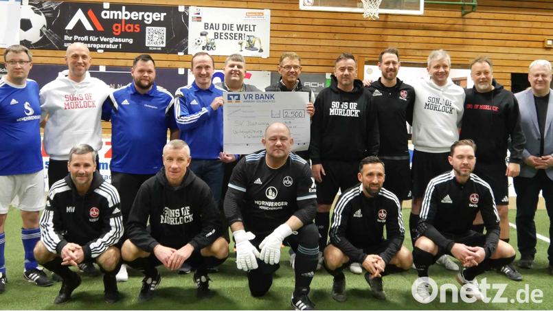 Die Traditionsmannschaft des 1. FC Nürnberg mit Teamchef Thomas Ziemer (stehend, Fünfter von rechts) und dem früheren Bundesliga-Torschützenkönig Marek Mintal (knieend, Zweiter von links) gesellt sich bei der Übergabe des 2500 Euro schweren Spendenschecks der VR-Bank an den SV Illschwang dazu. Bild: no