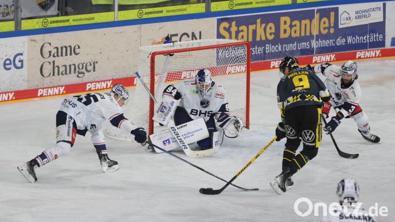 Tommy Muck (rechts, weißes Trikot), Niklas Länger (rechts) und Marco Wölfl (im Tor) im Verbund gegen Marcel Müller von den Krefeld Pinguinen. Die Weidener landeten beim Aufstiegsaspiranten einen 6:3-Auswärtscoup. Bild: Samla