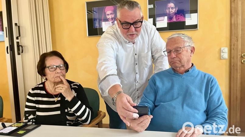 Der Seniorenbeauftragte Peter Klein (Mitte) prüft mit Franz-Josef Lang die App-Einstellungen. Bild: Gabi Schönberger
