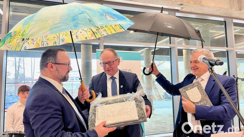 Jeweils einen Schirm des Landkreises und der Stadt Kemnath überreichten Landrat Roland Grillmeier und Bürgermeister Roman Schäffler an Schulleiter Holger König (von rechts). Dazu gab es noch ein Porzellanbild. Bild: Gabi Schönberger