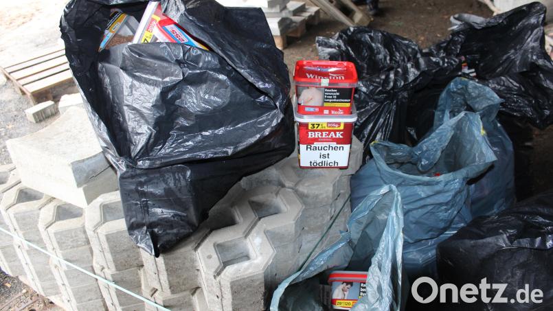 Nach der Festnahme der mutmaßliche Einbrecher entdeckten die Polizeibeamten versteckt zwischen Müllcontainern Abfallsäcke mit Tabakwaren, die zum Diebesgut gehören könnten. Bild: PP OPf