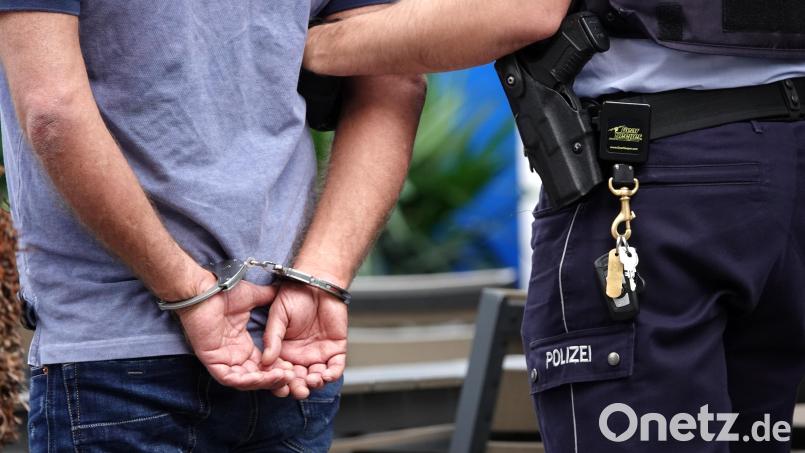 Ein Mann wird von einem Polizeibeamten verhaftet und abgeführt. Symbolbild: Johannes Neudecker