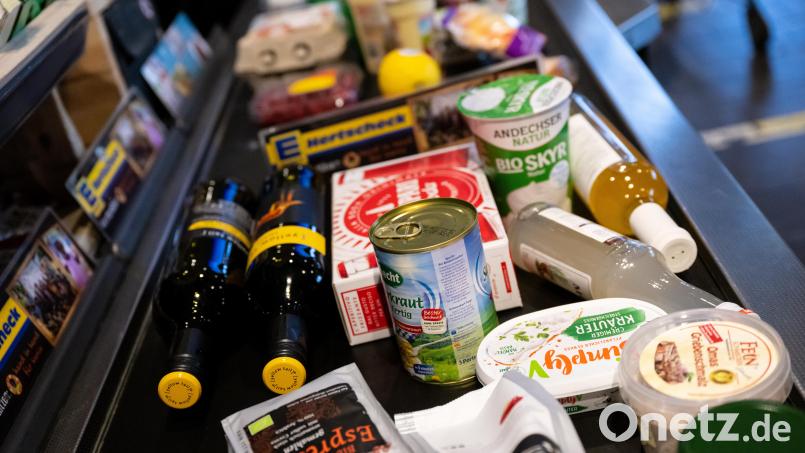 Lebensmittel liegen in einem Supermarkt an der Kasse auf dem Band. Symbolbild: Sven Hoppe/dpa