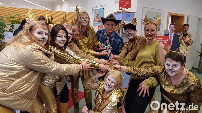 Die Hirschauer Narrhalla-Hirschis mit ihrer Präsidentin Regina Merkl (Dritte von rechts) und Prinzessin Anna-Lena I. (Fünfte von links) überfallen am Unsinnigen Donnerstag die Sparkassenfiliale. Deren Leiter Dominik Merkel (Mitte) büßt seine Krawatte ein, kann aber die Narrhallesinnen mit einem 400-Euro-Scheck besänftigen. Bild: u