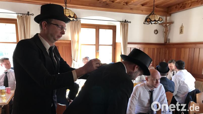 Ein Fisch mit Zylinder, auf den Anzugsrücken gemalt, ist wichtige Kennzeichnung der approbierten Teilnehmer beim Fischzug in Hahnbach. Bild: mma