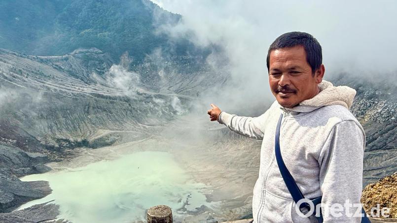 Der Souvenirverkäufer Hassan erklärt Touristen am Ratu-Krater die Besonderheiten der Caldera. Bild: Carola Frentzen/dpa