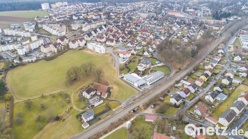Von der Loderhofstraße (etwa Bildmitte) führt bis dato nur ein Fußweg an einer Firma entlang zur Schillerstraße. Der Anschluss der Loderhofstraße an den Hitzelmühlweg direkt durch die Bahnunterführung oder an die Schillerstraße könnte nach Ansicht von Stadträten eine Entlastung der Verkehrssituation bringen – auch im Hinblick auf ein neues Baugebiet, das auf der großen Freifläche entstehen soll. Bild: Thilo Hierstetter