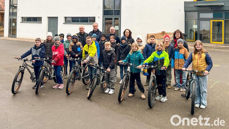Spendenübergabe an der Grundschule Neunburg: Lions-Mitglied Michael Steidl, Polizeioberkommissar Markus Schlegel von der Polizei Neunburg, Lions-Präsident Thorsten Matheja, Rektorin Sabine Bauer und die Verkehrs- und Sicherheitsbeauftragte der Grundschule, Heike Hanisch (hinten von links) freuten sich mit den Schülern, die die neuen Räder gleich ausprobierten. Bild: Marcus Paulus