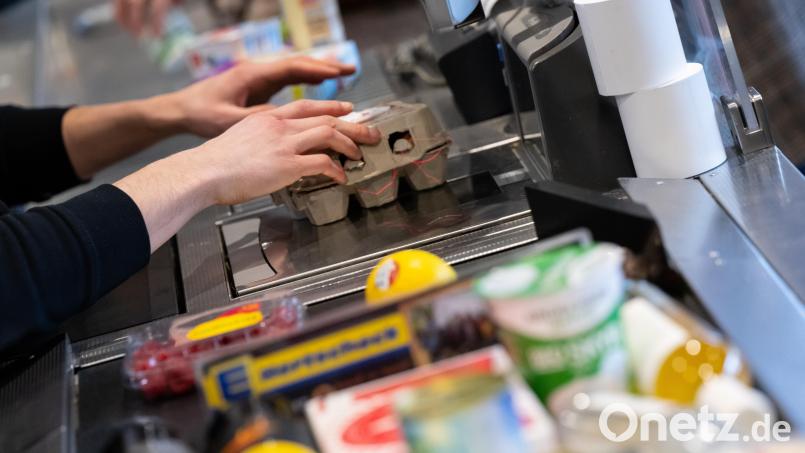 Ein Kassierer scannt in einem Supermarkt an der Kasse die Produkte. Symbolbild: Sven Hoppe/dpa