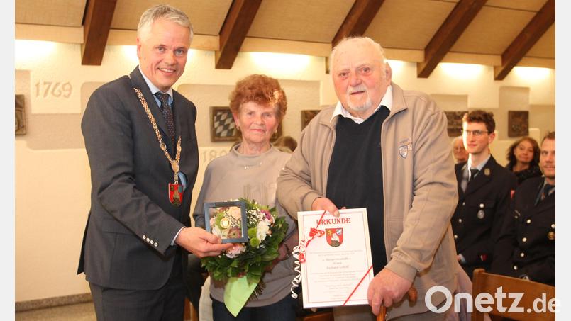 Richard Schedl (rechts) freut sich sichtlich über die von Bürgermeister Thomas Meiler verliehene Bürgermedaille, Ehefrau Hannelore über Blumen. Bild: pi