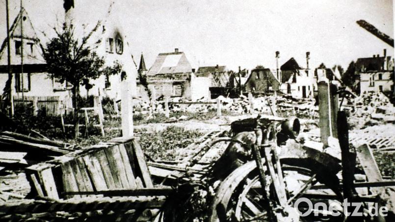 Nur noch Ruinen und Trümmer beim Blick von der Schönwerthstraße über die Neue Amberger Straße zur Altstadt. Zwischen den linken Giebeln ist der Kirchturm der Maria Himmelfahrtskirche zu erkennen. Nur noch die Außenmauern und Kamine stehen beim Doppelhaus Gebhardt-Knodt, dem Elternhaus von Maria Reiter, geborene Gebhardt (Ruine über dem Motorradlenker). Archivbild: Militärmuseum Grafenwöhr
