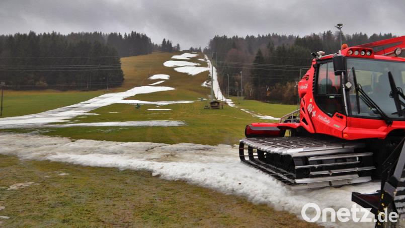 Eine Pistenraupe steht auf einer Skipiste, die nur noch teilweise mit Schneeresten bedeckt ist. Bild: Benjamin Liss