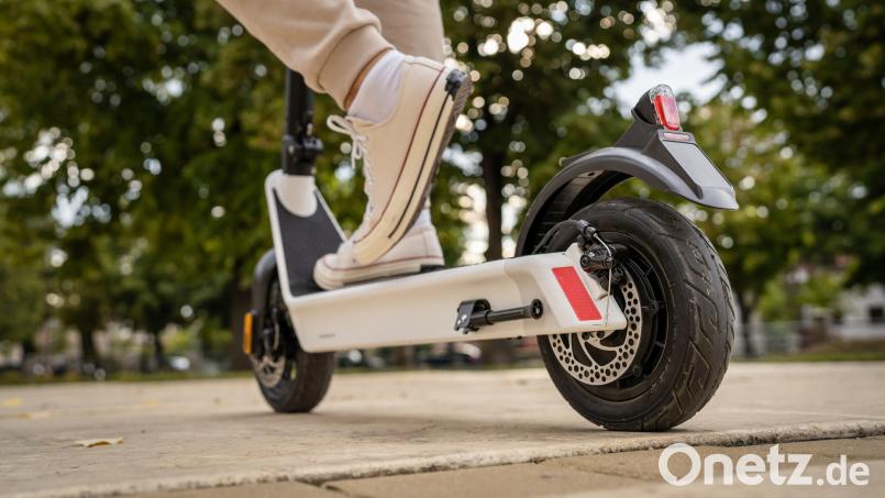 Feet of unknown man standing by or driving electric kick scooter e-scooter on the pavement in day eco friendly modern transport Symbolbild: Miljan Zivkovic - stock.adobe.com
