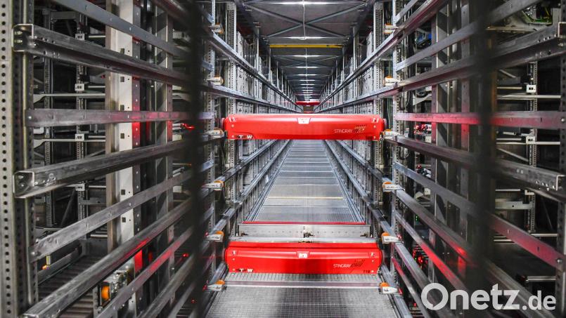 Im nagelneuen Shuttle-Lager sausen in ewig langen Gassen auf 250 unterschiedlichen Ebenen Hunderte der roten Transport-Gefährte völlig autonom umher: Sie holen Kisten mit Waren aus den Regalen oder lagern sie dort ein. Bild: Petra Hartl