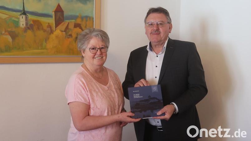 Autorin Rosi Hasenstab überrascht Bürgermeister Hans-Martin Schertl mit ihrem Buch über Vilseck. Bild: Stefanie Gradl