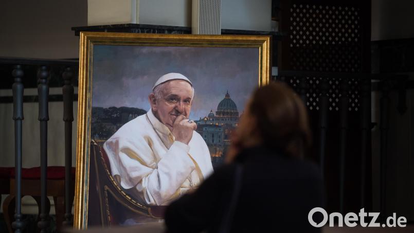 Eine Frau betet zu der Jungfrau neben einem Gemälde des verstorbenen Papstes Franziskus. Symbolbild: Jesus Merida/dpa