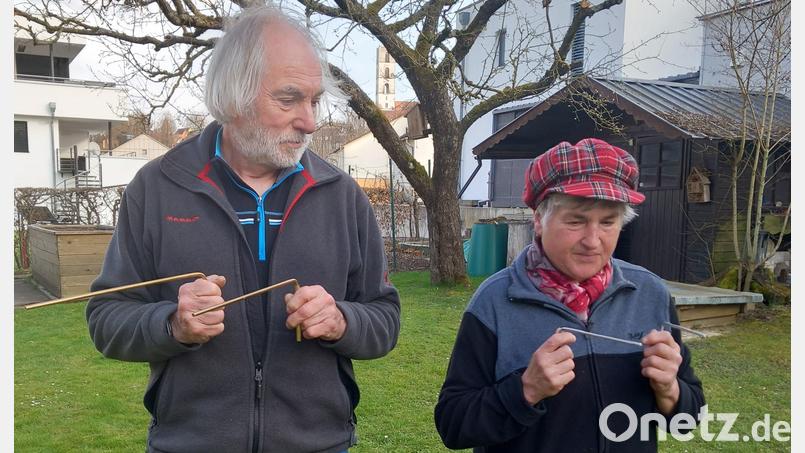 Willi Meiler und Rita Kordein spüren mit der Wünschelrute ein im Gartenboden verlegtes Kabel auf. Bild: hka
