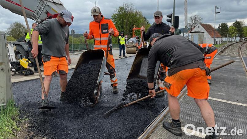 Richtung Naabbrücke wird nach den Stopfarbeiten der Bahn der Straßenasphalt aufgetragen und angeglichen.. Bild: ihl