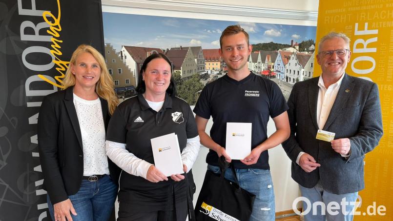 Sachbearbeiterin Barbara Aved (links) und OB Andreas Feller (rechts) überreichen Ehrenamtskarten an Melanie Rühl (SC Weinberg) und Thomas Dirmeier (FFW Fronberg). Weitere Engagierte erhielten ihre Karten per Post. Bild: Andreas Hofmeister/Stadt Schwandorf/exb