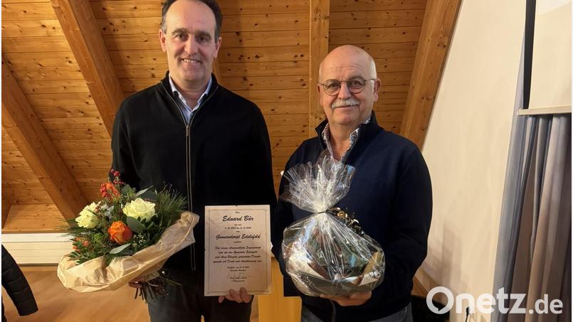 Bürgermeister Hans-Jürgen Strehl (links) dankte Eduard Bär für die langjährige ehrenamtliche Tätigkeit als Gemeinderat und übergab ein kleines Präsent mit einem Blumenstrauß. Bild: gru
