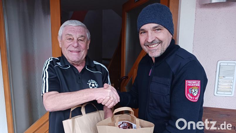 Altbürgermeister Gotthard Färber (links) hat für sich und seine Familie Weihnachtspackerl bestellt und erhält diese vom Feuerwehr-Vorsitzenden Armin Hofrichter. Bild: Michael Rabenhofer