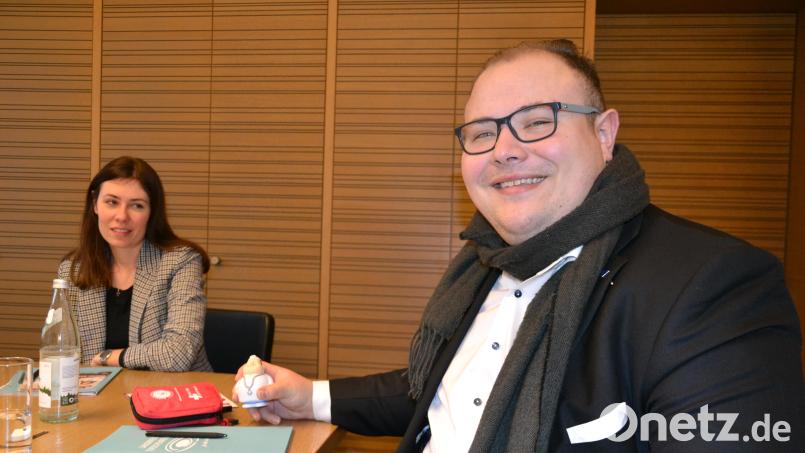 Sebastian Ponnath hat gerade die Vereinbarung für ein Landkreis-Stipendium unterschrieben. In der Hand hält er das Maskottchen der Hausarztschmiede, einen Ball zum Stressabbau in Form eines knuddeligen Doktors. Im Hintergrund ist Projekt-Koordinatorin Linda Wunderlich. Bild: as