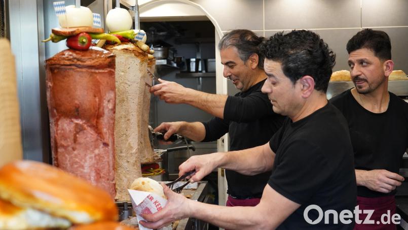 Marco Cakmak (links) bietet neben dem Leberkäs-Döner jetzt auch Varianten mit Weiß- und Bratwurst an. Mit seinem Mitarbeiter Turhan Bakir (Mitte) schneidet er das Brät vom Spieß. Huseyin Cakmak verpackt die Bestellungen. Bild: kaz