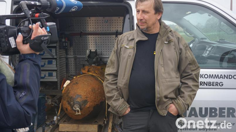 Lässig neben der Bombe: Nach getaner Arbeit beantwortet Sprengmeister Michael Weiß die Fragen der Pressevertreter. Zuvor hatte er eine 450-Kilo-Fliegerbombe in Amberg entschärft – unter besonderen Umständen. Bild: jut