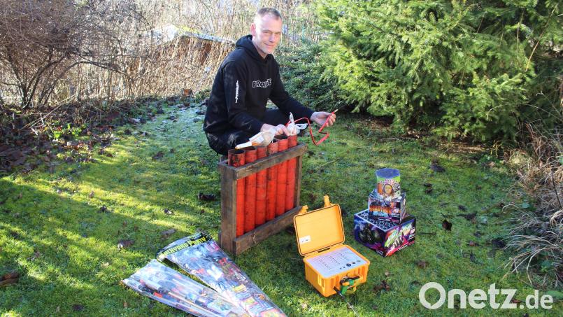 Der &quot;Pyrohase&quot; in Aktion: Pyrotechniker Armin Hase mit explosiven Materialien in seinem Garten. In der Hand hält der Feuerwerker eine Kugelbombe, die durch ein Bombenrohr in den Himmel geschossen wird. Der kleine gelbe Koffer davor ist eine Funkzündanlage. Rechts und links daneben liegen freiverkäufliche Kleinfeuerwerke. Bild: Jennifer Battaglia