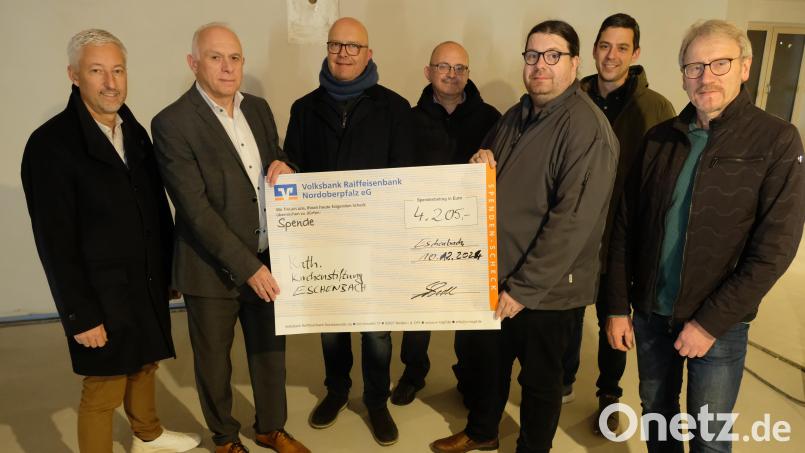 Den symbolischen Scheck der Cowdfunding-Aktion überreichten im Rohbau des Pfarrheimes die Vertreter der VR-Bank an Pfarrer Johannes Bosco (Dritter von rechts) und an die Mitglieder der Kirchenverwaltung. Bild: do