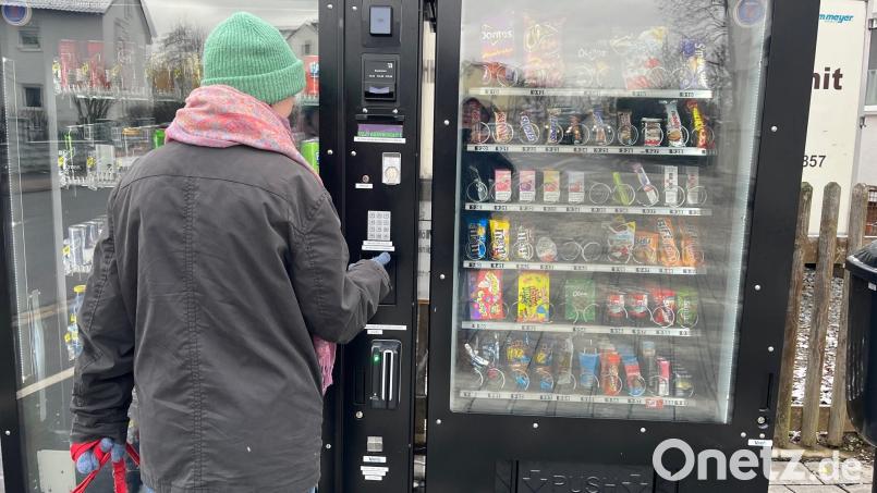 Eine junge Frau versorgt sich an diesem Automaten in der Mooslohe in Weiden mit Getränken und Snacks. Bild: Gabi Schönberger