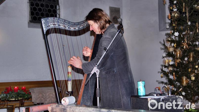 Andy Lang begleitete seine Liedvorträge vor dem Altar der St.-Nikolauskirche meisterhaft an der Harfe. Bild: ds