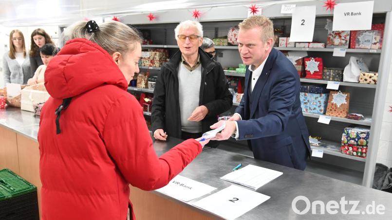 Die Vertreter der Päckchen-Spender halfen bei der Verteilung mit, auf unserem Foto der VR-Bank-Vorstand Martin Sachsenhauser (rechts) der den Tafel-Vorsitzenden Bernhard Saurenbach unterstützt. Bild: gf