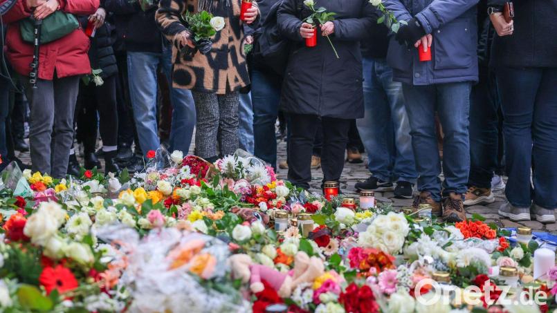 Menschen legen Blumen und Kerzen am offiziellen Gedenkort nach Todesfahrt auf Weihnachtsmarkt in Magdeburg an der Johanniskirche nieder. Am Vorabend war ein Autofahrer auf dem Magdeburger Weihnachtsmarkt in eine Menschengruppe gefahren. Es gab mehrere Tote und Verletzte. Bild: Jan Woitas/dpa
