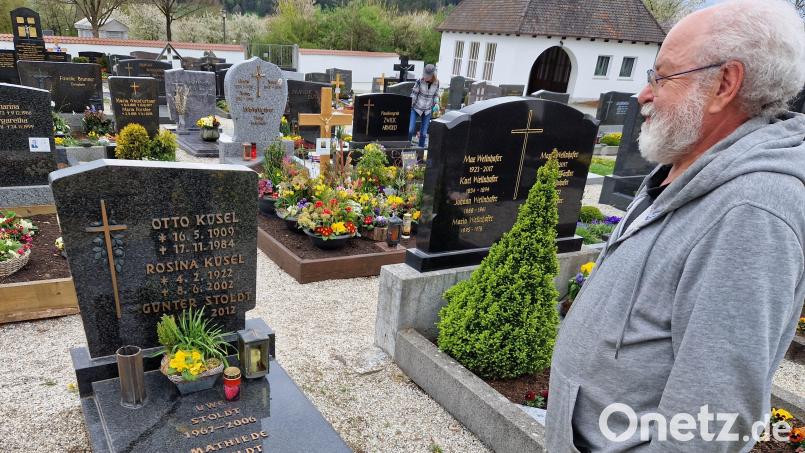 Heimatforscher und Historiker Alfred Wolfsteiner am Grab der Familie Küsel in Schwarzhofen. Ganz oben steht der Name von Otto Küsel, ein gebürtiger Berliner, darunter seine Frau Rosina. Die beiden haben sich nach dem Krieg in Schwarzhofen kennengelernt. Bild: Thomas Dobler