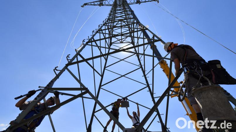 Monteure arbeiten an einem neuen Mast für eine zukünftige Bahnstromtrasse. Gegen den Stromtrassenverlauf für die Elektrifizierung der Bahnstrecke von Regensburg nach Hof regt sich nun Widerstand. Symbolbild: Martin Schutt/dpa