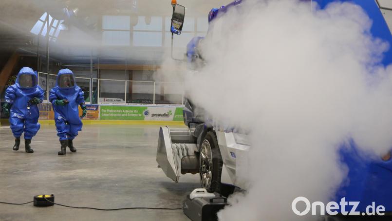 Wie in einem Katastrophenfilm: Zwei Männer in blauen Chemieschutzanzügen nähern sich einer giftigen Gaswolke - eine Großübung in der Amberger Eishalle. Bild: Wolfgang Steinbacher