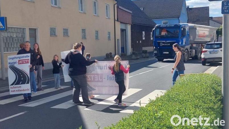 In einer weiteren Spontanaktion bremsten Anlieger der Hüttener Straße und Mitglieder der Bürgerinitiative „Umgehungsstraße Mantel – jetzt!“ den Verkehrsfluss am Zebrastreifen beim „Hauptmann“ und machten mit Transparenten auf die Notwendigkeit der Umgehungsstraße aufmerksam. Bild: knh