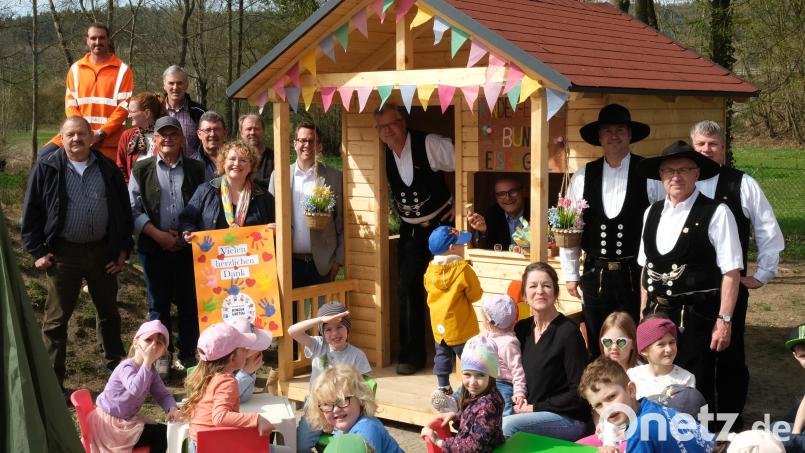 Bürgermeister Maximilian Beer und Obermeister Richard Kurz verteilen vom neuen Spielhaus „Bunte Eiskugel“ heraus Süßigkeiten an die Kinder. Mit im Bild Vertreter der Zimmerer-Innung, der Kreishandwerkerschaft und des Gemeinderates Schwarzhofen. Bild: Rudolf Hirsch/exb