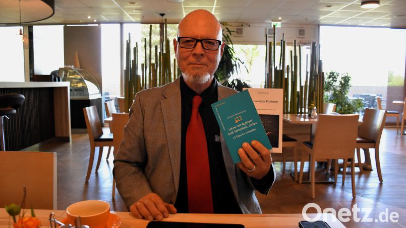 Martin Hauk zeigt das von ihm verfasste Buch &quot;Lehrer mit Asperger: Cool, kompetent, anders – 22 Tipps für Lehrkräfte&quot;. Bild: ubb